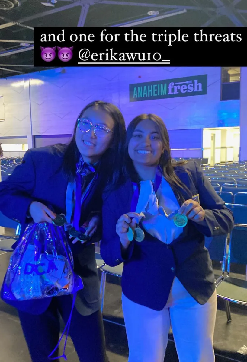 Two DECA competitors showing their medals after the awards ceremony