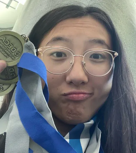 Erika Wu holding her DECA medals